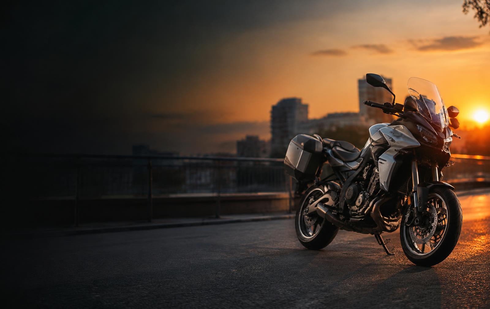 Moto touring estacionada en una vía urbana al atardecer